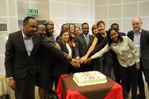 Photo of members of the consortium cutting a cake at the launch