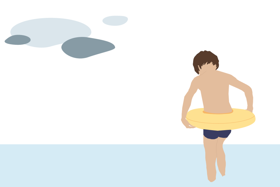gutt som bader i vannkanten med badering. det er overskyet.